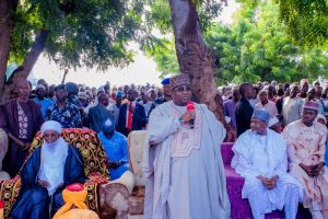 Kebbi State Governor Dr. Nasir Idris addressing IDPs, while Speaker Kebbi State House of Assembly (R) Hon. Muhammad Usman Zuru and Emir of Yauri, Dr. Muhammad Zayyanu Abdullahi watched (sitting)